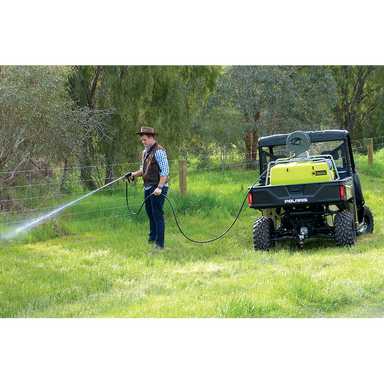 Operator spraying a fence line with the ReelStrike 200L hose reel from a UTV
