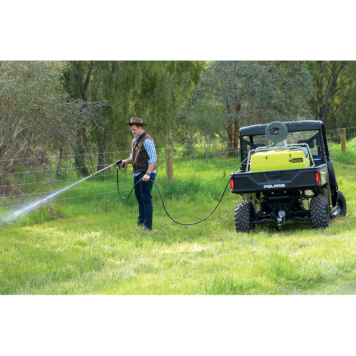 Operator spraying a fence line with the ReelStrike 200L hose reel from a UTV