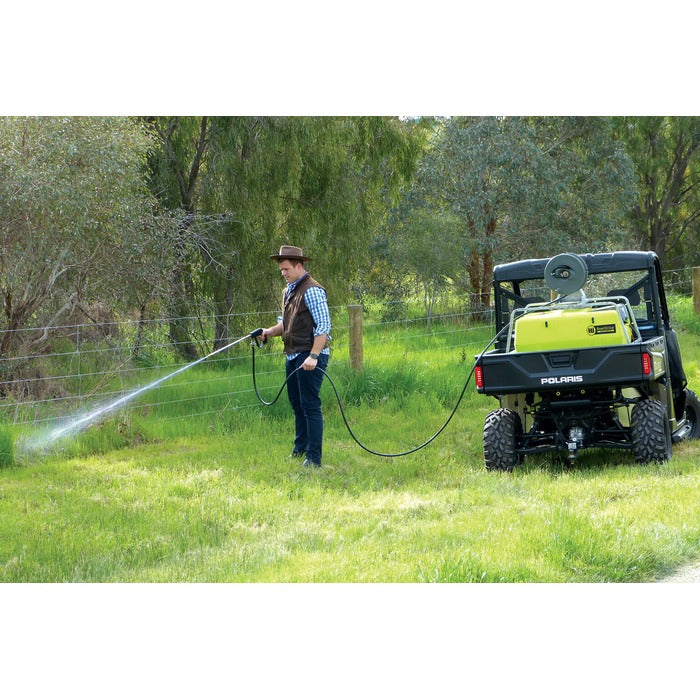 Operator spraying a fence line with the ReelStrike hose reel from a UTV