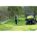 Operator spraying a fence line with the ReelStrike hose reel from a UTV